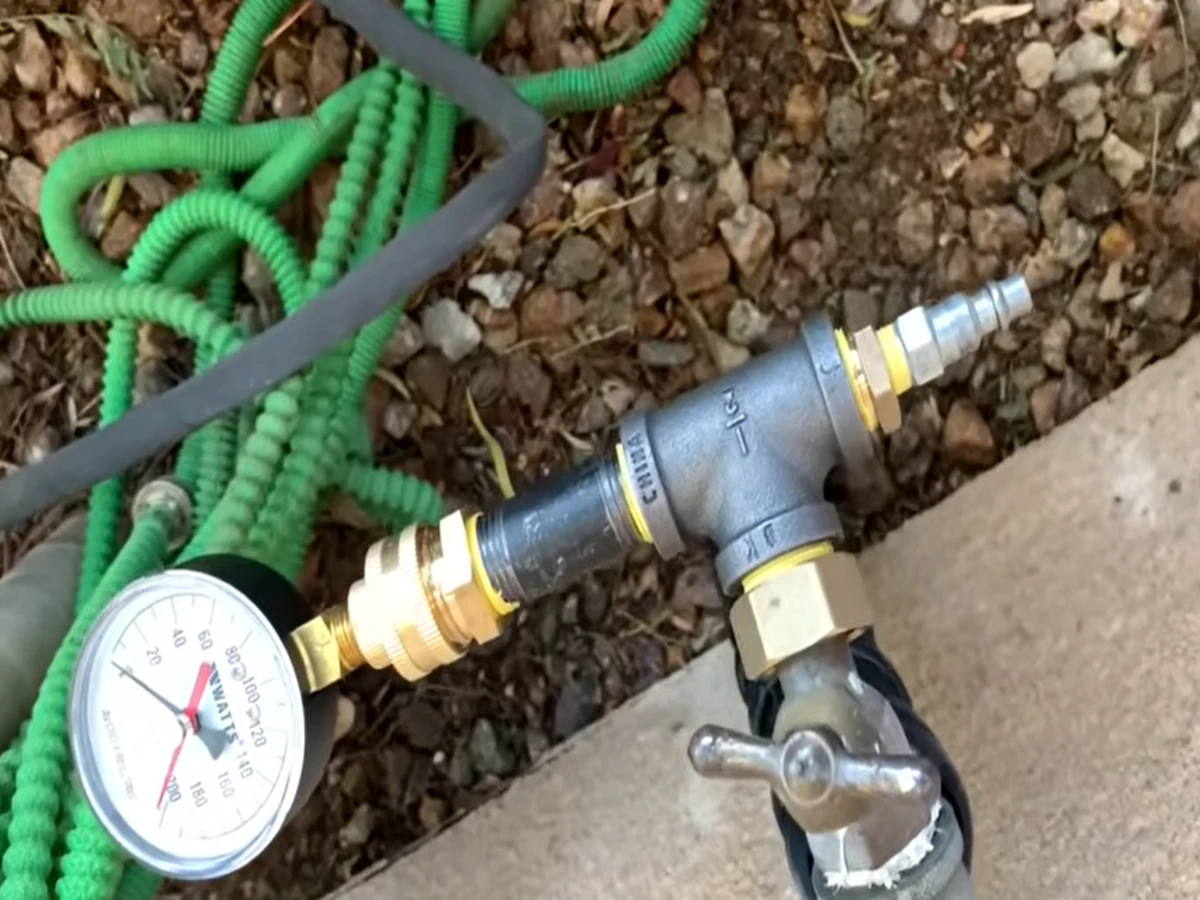 Pressure testing equipment connected to an outdoor hose bib to check for underground pipe leaks in Torrance