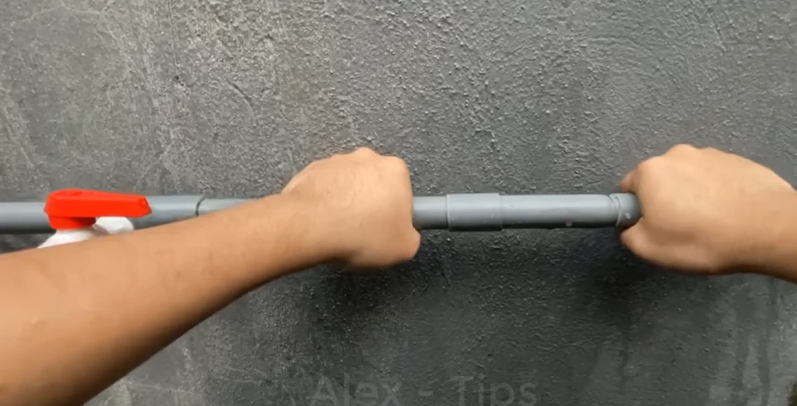 Close-up of water spraying from a cracked pipe fitting before repair